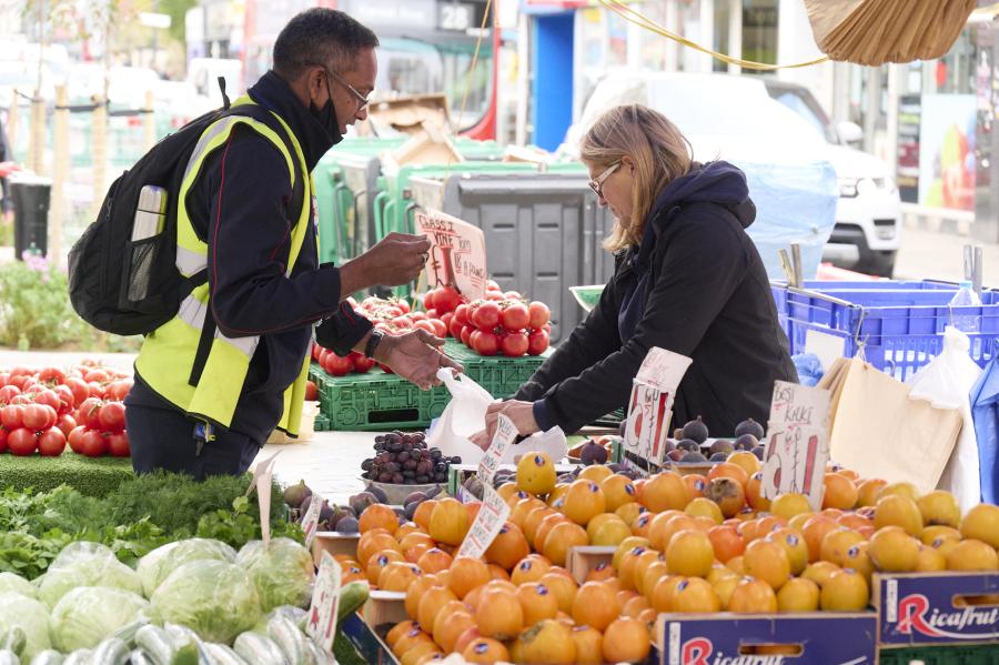 Customer buying fruit at a North End Road market stall