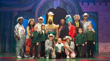 Lyric panto cast 2024 with H&F Cllr Sharon Holder (back, centre) and pupils from Wendell Park primary school in Shepherds Bush