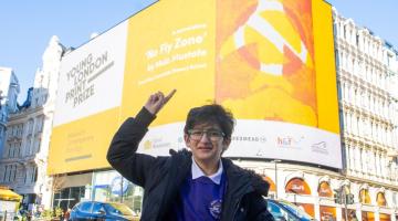 Muiz Mustafa showing off his winning print 'No Fly Zone' in Piccadilly Circus