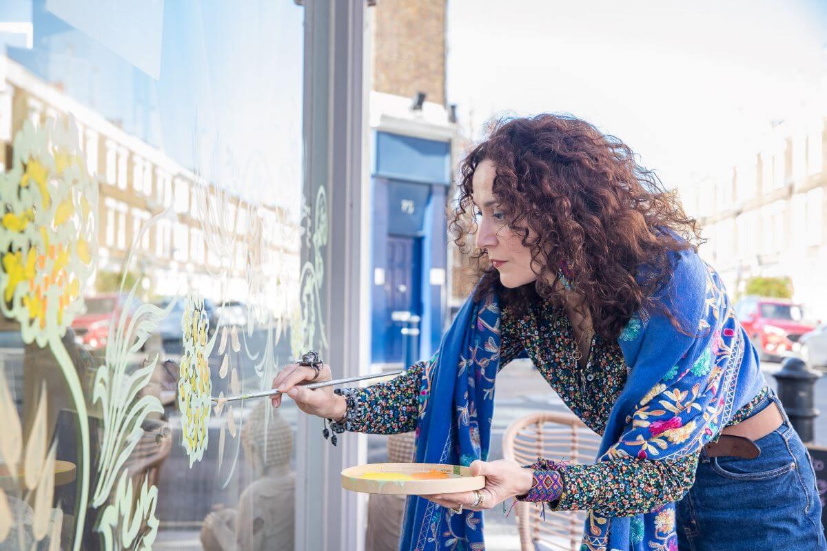 Naila Hazell painting a shop window