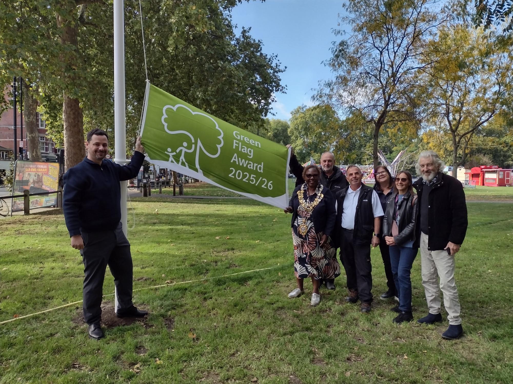 Mayor Cllr Sharon Holder and Cllr Florian Chevoppe-Verdier help raise the Green Flag in Eelbrook Common