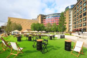 Artificial grass, tables and chairs with the Television Centre in the background