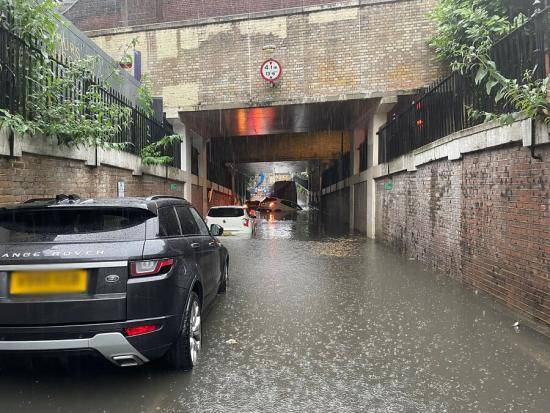 Torrential rain and flooding on Leamore Street in Hammersmith.