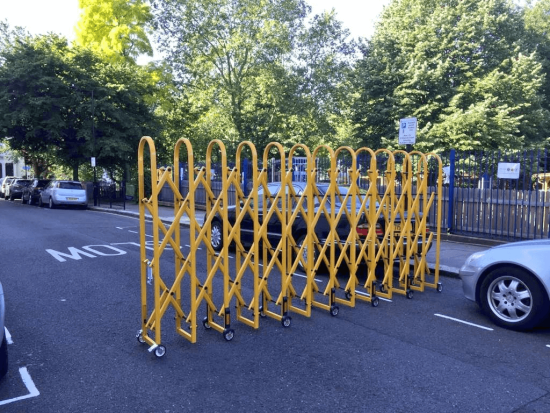 School street plus barrier - an expandable metal construction on wheels that can be opened out to the width of the road.