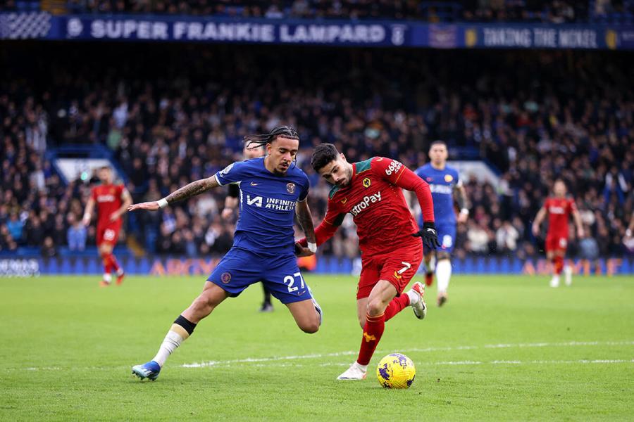 Malo Gusto of Chelsea (left) is closed down by Pedro Neto of Wolves