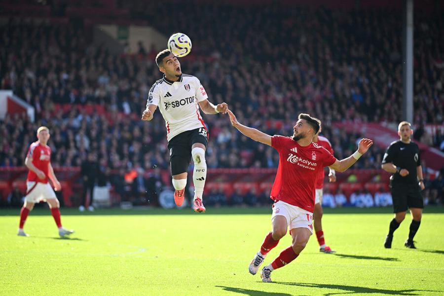 Andreas Pereira of Fulham (centre) heads the ball under pressure from Alex Moreno of Nottingham Forest