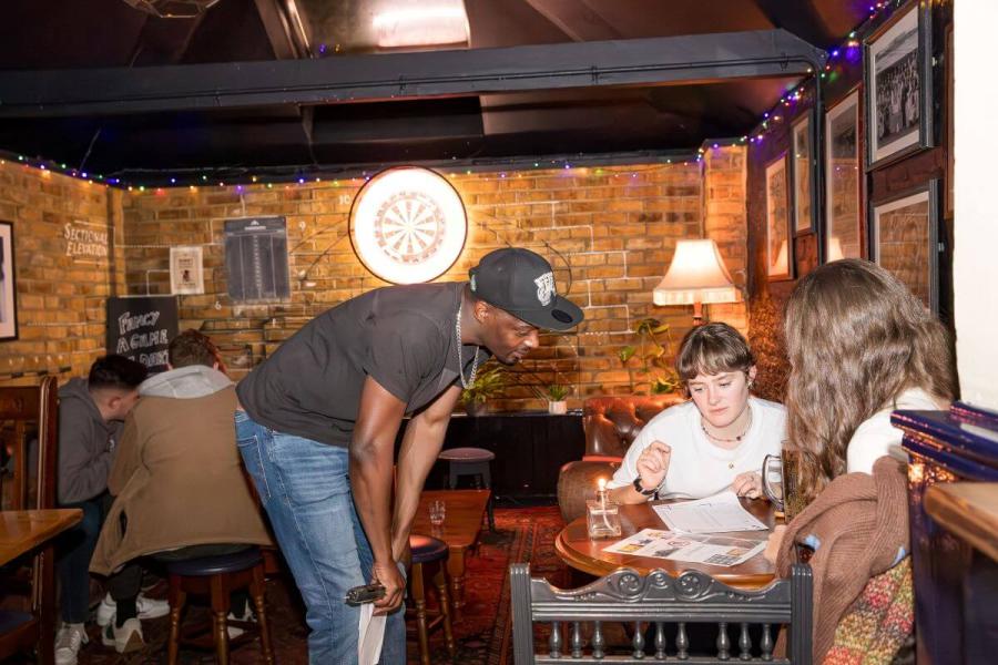 Quizmaster Tony speaking with a team